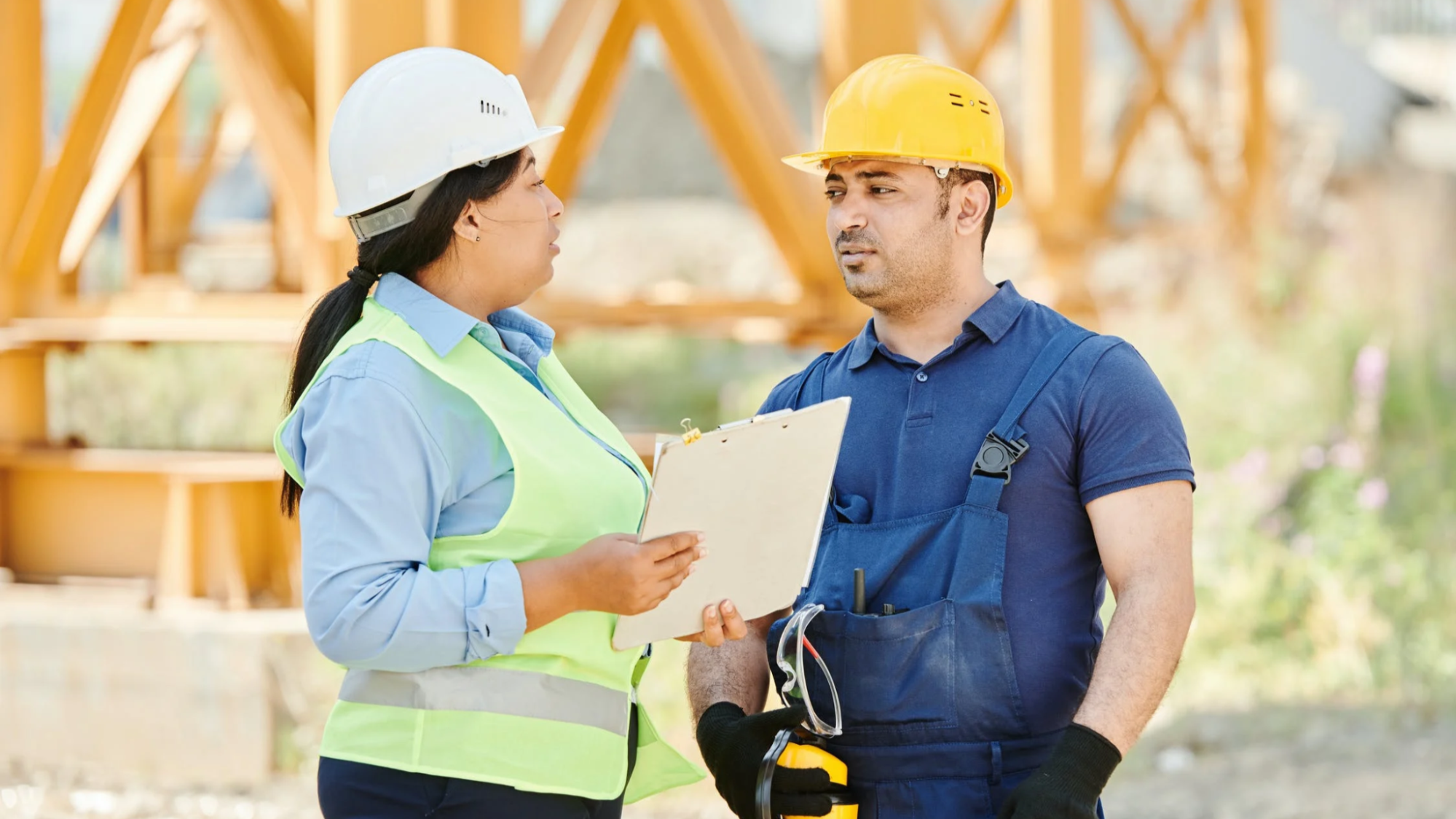 Two construction workers speaking with one another